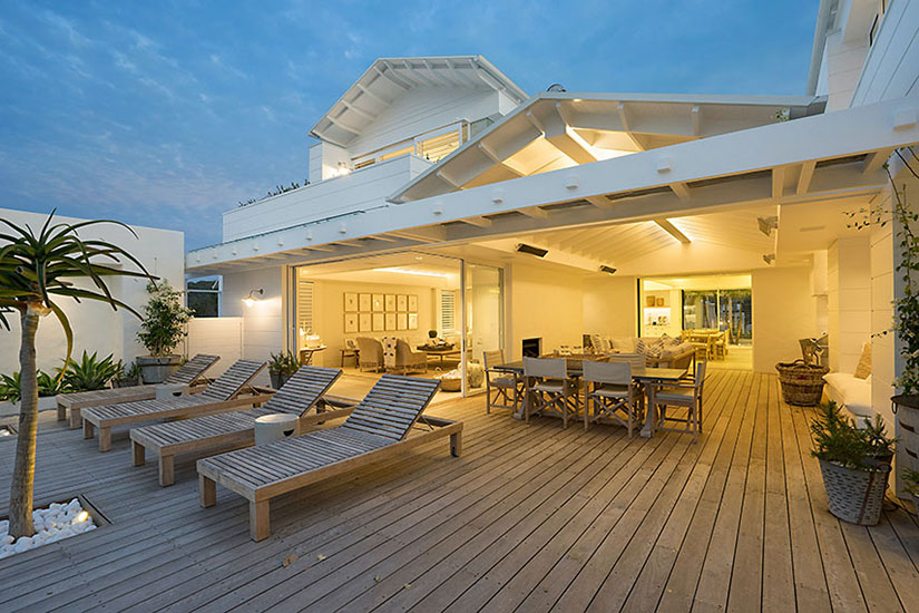 A large modern deck next to a luxury home.
