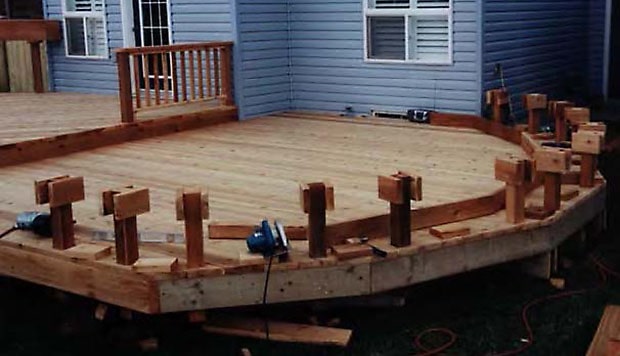 A wrap around bench under construction, attached to the deck.