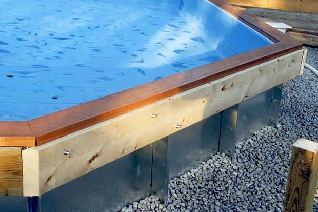 On-ground pool with ledger board bolted to the metal flange.