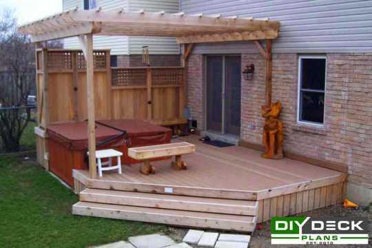 Single level deck built around a spa with a privacy screen and pergola.