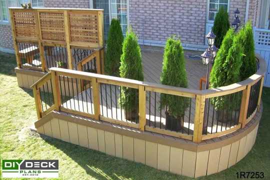 Deck with a bench and a curved front face attahced to a brick house.