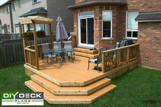 Medium size deck with a small pergola in one corner attached to a red brick house.