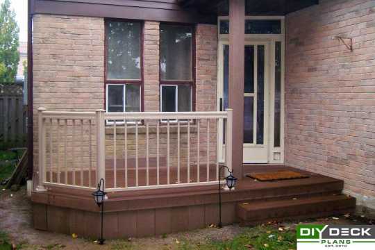 Small single level deck at the front door of a house.