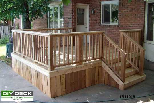 Single level deck attached to a red brick house.