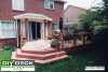 Medium size low single level deck attached to a red brick house.