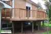 Medium sized single level deck with privacy screens attached to a red brick house.