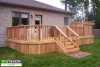 Front left view of a medium size deck with a privacy screen attached to a house.