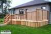 Front right view of a medium size deck with a privacy screen attached to a house.